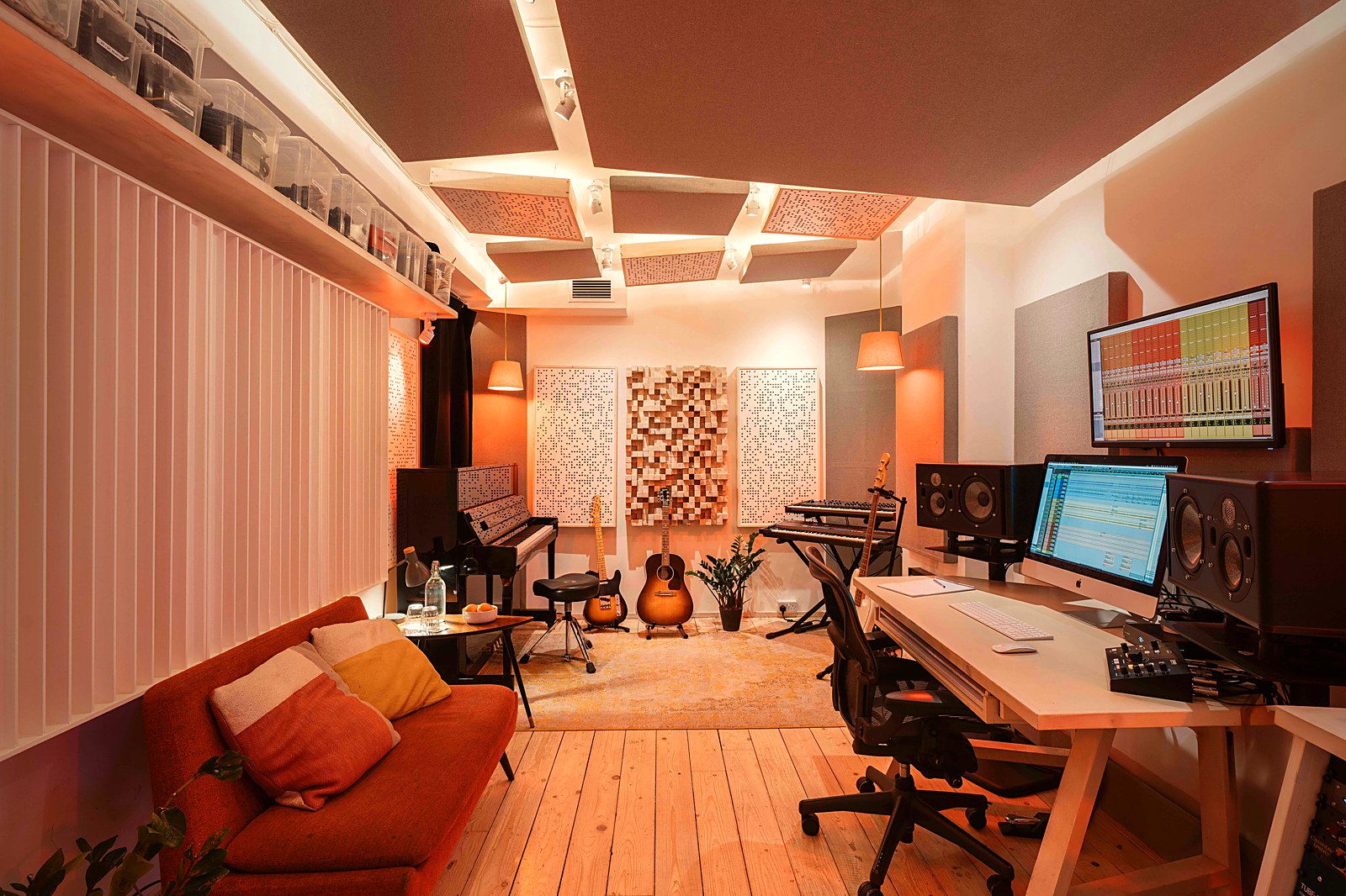 The studio room, warm lamplight, piano, guitars and a mixing desk
